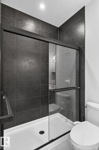 Shower enclosure featuring matte black framing and a sliding glass door - 16304 19 Avenue Sw, Edmonton, AB 