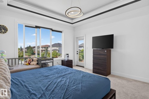 Room featuring broad windows, a tray ceiling with black trim, and recessed lighting - 16304 19 Avenue Sw, Edmonton, AB 