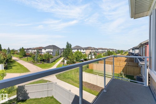 Private balcony with glass railing, concrete flooring, and surrounding neighborhood views - 16304 19 Avenue Sw, Edmonton, AB 