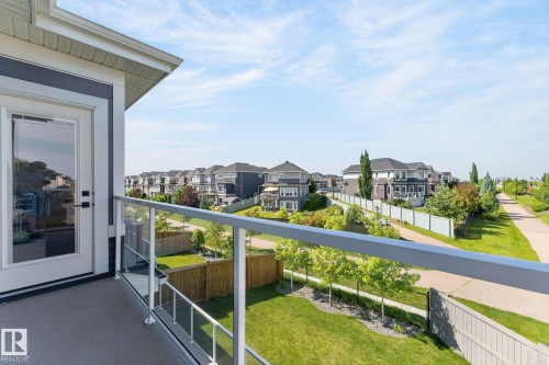 Balcony featuring a glass railing system, a white framed door with a large glass pane, and a concrete surface - 16304 19 Avenue Sw, Edmonton, AB 