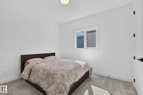 Bright room with white painted walls, grey carpet flooring, and a flush-mount ceiling light fixture - 16304 19 Avenue Sw, Edmonton, AB 