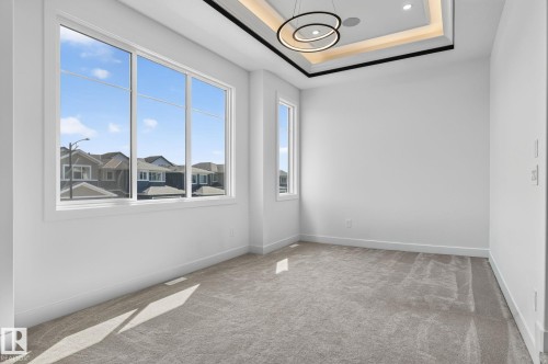 Bright interior space featuring multi-pane windows and a sophisticated tray ceiling with integrated lighting - 16304 19 Avenue Sw, Edmonton, AB 