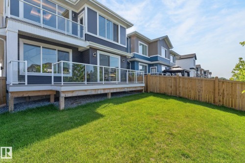 Expansive green lawn with a wooden privacy fence - 16304 19 Avenue Sw, Edmonton, AB 