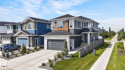 Modern two-story residence featuring a dark gray and wood-tone exterior with a light stone accent facade - 16304 19 Avenue Sw, Edmonton, AB 
