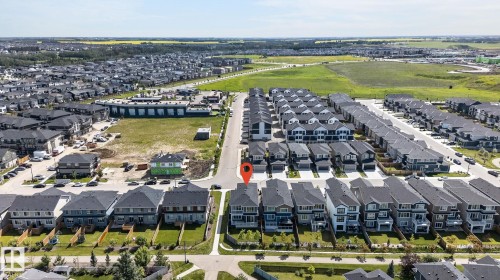 Aerial perspective showcasing a residential development with structured street layouts and a mix of detached and attached homes - 16304 19 Avenue Sw, Edmonton, AB 
