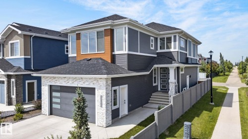 Contemporary two-story residence featuring a dark gray siding exterior with stone veneer accents - 16304 19 Avenue Sw, Edmonton, AB 