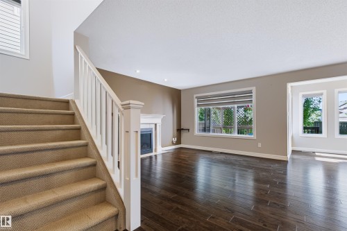 Wood-finish flooring, recessed lighting, and a fireplace with a mantel - 1420 158 Street Sw, Edmonton, AB 
