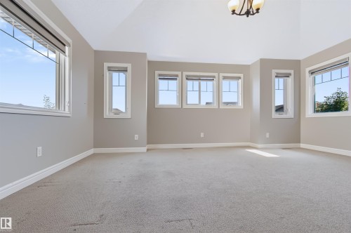 Vaulted ceiling, multiple windows, neutral wall color, carpeted flooring, decorative ceiling fixture - 1420 158 Street Sw, Edmonton, AB 