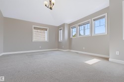 Neutral wall tones, multiple windows with white trim, vaulted ceiling, and recessed lighting fixture - 