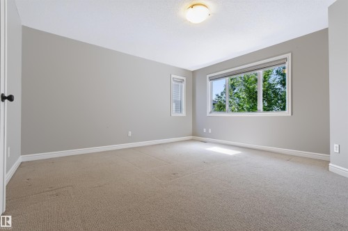Neutral wall paint, carpeted flooring, two windows, and a flush-mount ceiling light - 1420 158 Street Sw, Edmonton, AB 