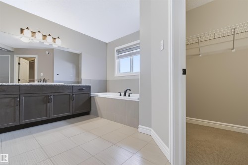 Dual vanity with dark wood cabinetry, granite countertop, and integrated sinks - 1420 158 Street Sw, Edmonton, AB 