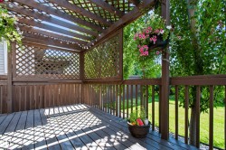 Wood deck with open pergola, lattice privacy screens, and wood railings - 