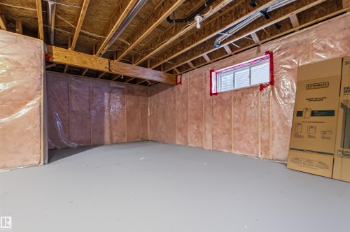 Unfinished basement with exposed wood joists and subflooring, insulated walls, and a small window - 1420 158 Street Sw, Edmonton, AB 
