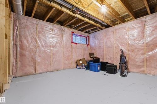 Unfinished basement featuring exposed wood framing, ceiling joists, and insulation - 1420 158 Street Sw, Edmonton, AB 
