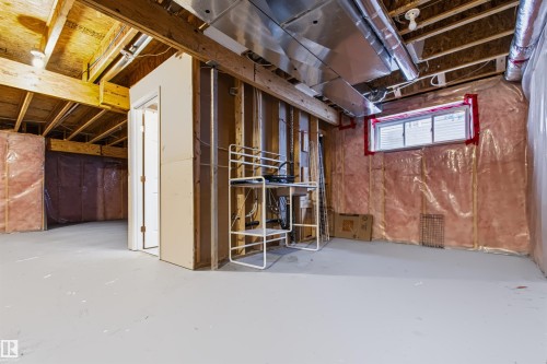 Unfinished basement offering exposed ceiling joists, visible insulation, a framed utility room, and a horizontal sliding window - 1420 158 Street Sw, Edmonton, AB 