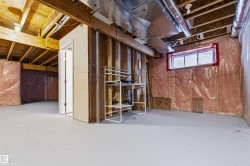 Unfinished basement offering exposed ceiling joists, visible insulation, a framed utility room, and a horizontal sliding window - 