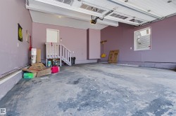 Roll-up garage door with automatic opener, concrete flooring, window for natural light, and interior access door - 