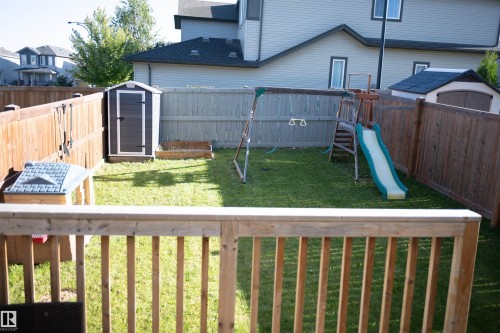 Fenced backyard featuring a manicured lawn, a built-in storage shed, and a raised planter box - 9014 Cooper Link Link Sw, Edmonton, AB 