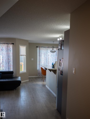 Wood-finish flooring throughout, bay windows, built-in breakfast bar, and a contemporary chandelier - 9014 Cooper Link Link Sw, Edmonton, AB 