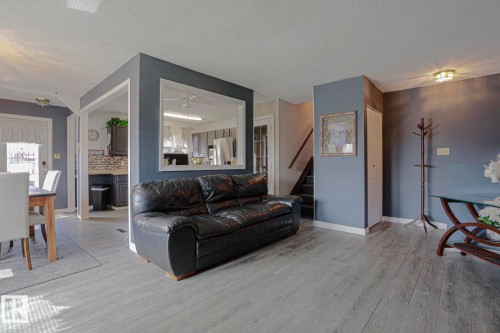 Wood-finish flooring throughout, framed openings, and a staircase with wood handrails - 11440 144 Avenue Nw, Edmonton, AB 