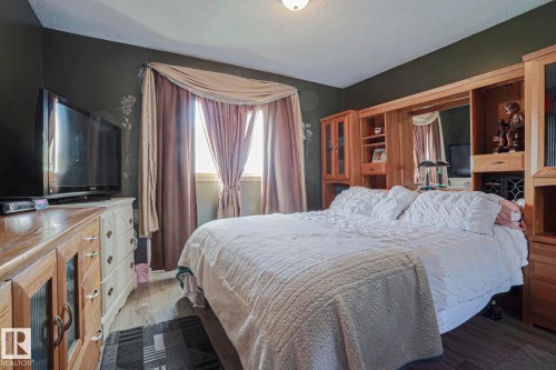 Wood-finish flooring with a built-in wall unit featuring shelving and cabinetry - 11440 144 Avenue Nw, Edmonton, AB 