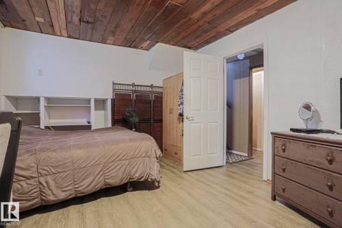 Wood-plank ceiling, built-in shelving, paneled interior door, and wood-finish flooring - 11440 144 Avenue Nw, Edmonton, AB 