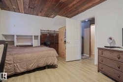 Wood-plank ceiling, built-in shelving, paneled interior door, and wood-finish flooring - 