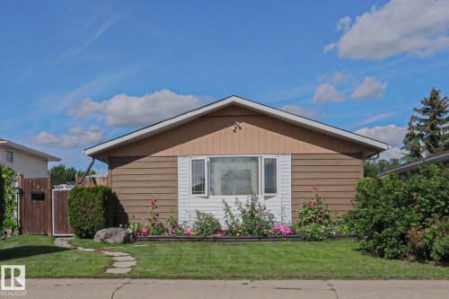 Single-story residence featuring horizontal siding, a gabled roofline, and a bay window - 11440 144 Avenue Nw, Edmonton, AB 