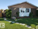 Front exterior featuring brown siding, a white window bay, and a light brown gable - 11440 144 Avenue Nw, Edmonton, AB 