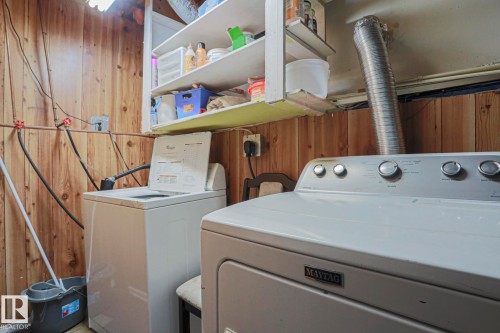 Wood-paneled room featuring built-in shelving and utility hookups - 11440 144 Avenue Nw, Edmonton, AB 
