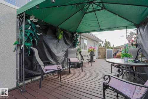 Expansive wood-finish deck with a covered gazebo, offering an outdoor living area - 11440 144 Avenue Nw, Edmonton, AB 
