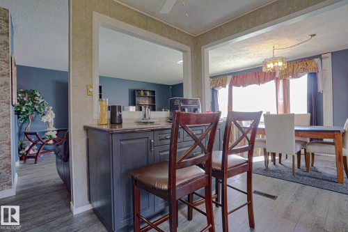 Kitchen pass-through with dark cabinetry, integrated sink, and countertop - 11440 144 Avenue Nw, Edmonton, AB 