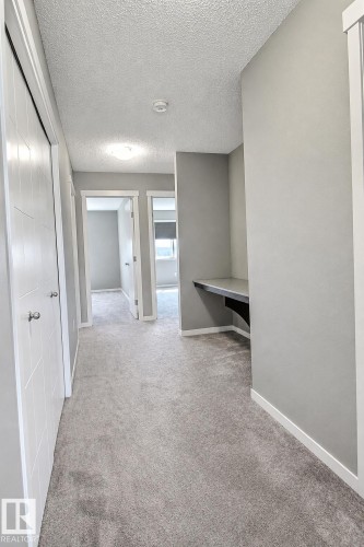 Integrated built-in desk, plush gray carpeting, white trim, and a flush mount ceiling light - 4847 173 Avenue Nw, Edmonton, AB 