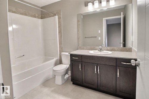 White integrated tub and shower unit with tile surround - 4847 173 Avenue Nw, Edmonton, AB 