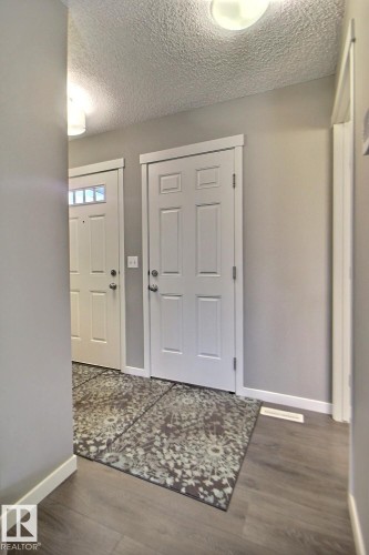 Wood-finish flooring, white panel doors, and flush mount lighting - 4847 173 Avenue Nw, Edmonton, AB 