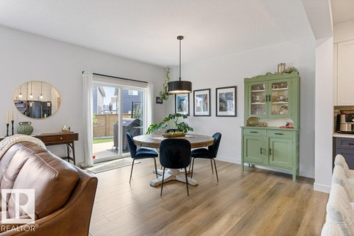 Wood-finish flooring, sliding glass patio door, recessed lighting, and a contemporary pendant light fixture - 34 Raspberry Road, St. Albert, AB 