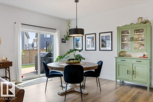 Wood-finish flooring throughout, white walls, and a contemporary drum pendant light fixture - 34 Raspberry Road, St. Albert, AB 