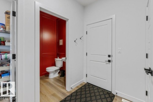 Powder room with a pedestal sink, toilet, and wood-finish flooring - 34 Raspberry Road, St. Albert, AB 