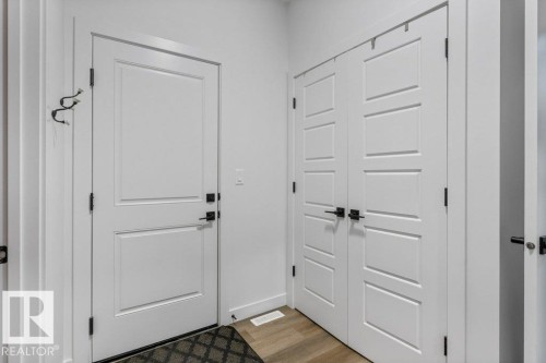 White paneled entry door with black hardware - 34 Raspberry Road, St. Albert, AB 