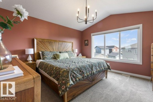 Vaulted ceiling with an overhead chandelier, large picture window, and neutral carpeting - 34 Raspberry Road, St. Albert, AB 