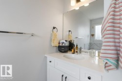 White vanity with black hardware, under-mount sink, and a chrome faucet - 
