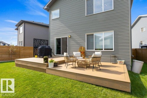 Expansive deck with composite material, featuring a sliding glass door and direct access to a grassy yard - 34 Raspberry Road, St. Albert, AB 