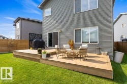 Expansive deck with composite material, featuring a sliding glass door and direct access to a grassy yard - 