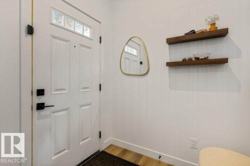 Entryway featuring a white paneled door with transom windows and matte black hardware - 34 Raspberry Road, St. Albert, AB 