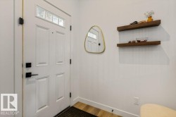 Entryway featuring a white paneled door with transom windows and matte black hardware - 