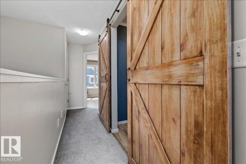 Barn door entry to a room with dark accent wall - #31 603 Watt Bv Sw, Edmonton, AB - Indoor Photo Showing Other Room