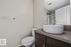 Bathroom vanity featuring a vessel sink, single-handle faucet, and dark wood-finish cabinetry - 