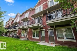 Townhome exterior featuring red siding and white trim - 