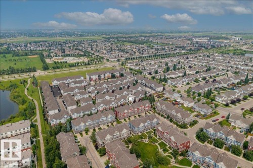 Aerial perspective showcasing a residential community with diverse housing types - #31 603 Watt Bv Sw, Edmonton, AB - Outdoor With View