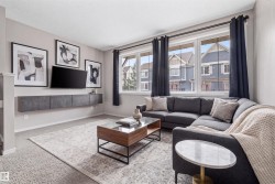 Living space featuring light gray wall paint, wall-to-wall carpeting, and a built-in wall-mounted media console - 